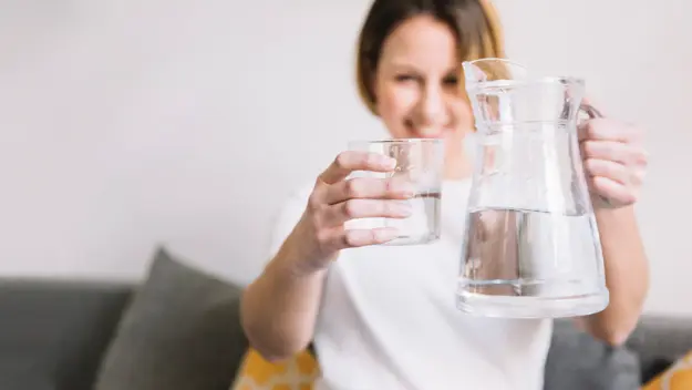 Importancia de tomar agua. Mujer borrosa tomando agua filtrada